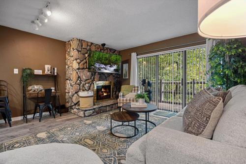 a living room with a couch and a stone fireplace at Bearadise Mountain Getaway by Eden Crest in Sevierville
