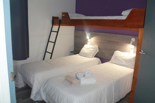 two beds in a room with two bunk beds at FASTHOTEL A Dijon in Dijon