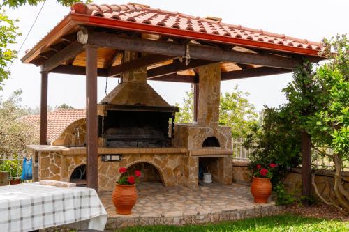 an outdoor pizza oven with a roof on a patio at Apartment’s Vasileiou Suite 1 in Preveza
