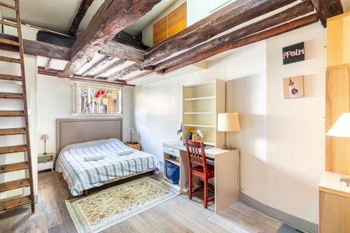 une chambre avec un lit et un bureau dans l'établissement GuestReady - Appartement élégant au cœur de Paris, à Paris