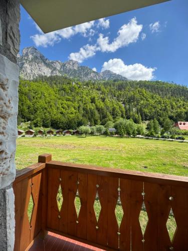 a balcony with a view of a field and mountains at Oda N'Bjeshke in Valbonë