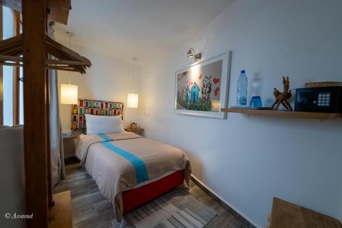 ein Schlafzimmer mit einem Bett und einem Bild an der Wand in der Unterkunft La Petite Chefchaouen in Chefchaouen