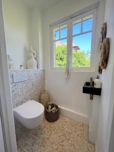 une salle de bain avec toilettes et fenêtre dans l'établissement Maison la corniche, à Blonville-sur-Mer