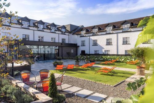 an exterior view of a hotel with chairs and a garden at The Swan Hotel and Spa in Newby Bridge