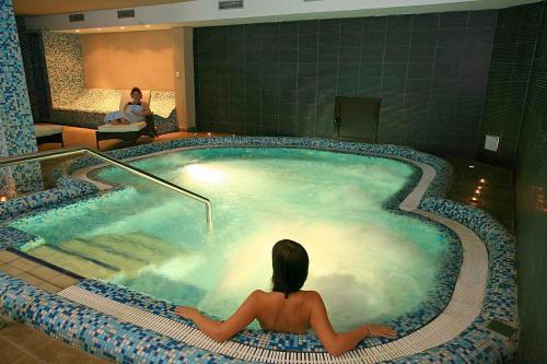 a woman sitting in a hot tub in a hotel at Marko Polo Maradiso Hotel by Aminess in Korčula
