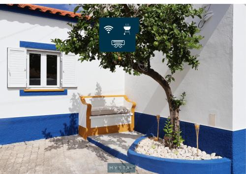 a tree in front of a building with a window at MyStay - Cantinho do Açor in Vale de Açor