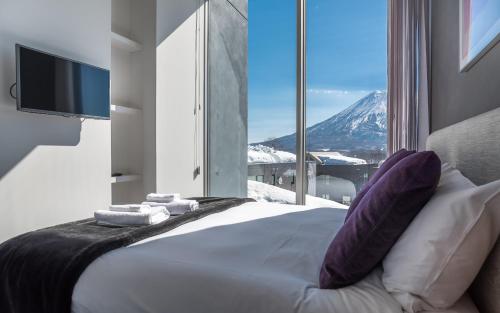 a bedroom with a bed with a view of a mountain at Terrazze in Kutchan