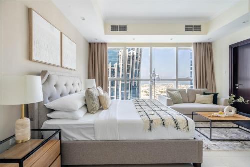 a bedroom with a large bed and a living room at GuestReady - Refúgio de luxo em Business Bay in Dubai