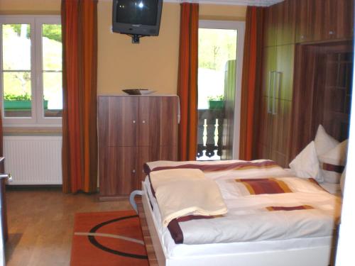 a bedroom with a bed and a tv in it at Hotel Restaurant Hausberg Garmisch-Partenkirchen in Garmisch-Partenkirchen