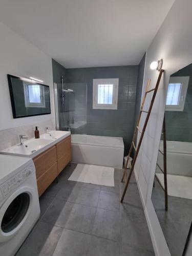 une salle de bain avec un lavabo et une machine à laver dans l'établissement Belle Villa bassin d'Arcachon, à La Teste-de-Buch