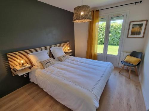 une chambre avec un grand lit blanc et une fenêtre dans l'établissement Belle Villa bassin d'Arcachon, à La Teste-de-Buch