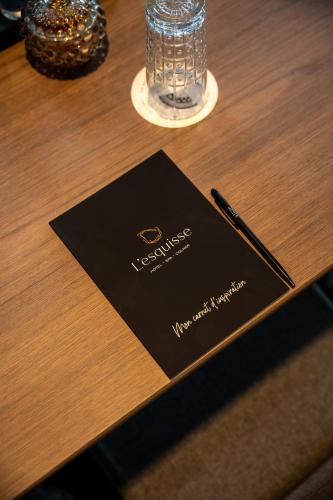 a card on a table with a pen on it at L'Esquisse Hotel & Spa Colmar - MGallery Collection in Colmar