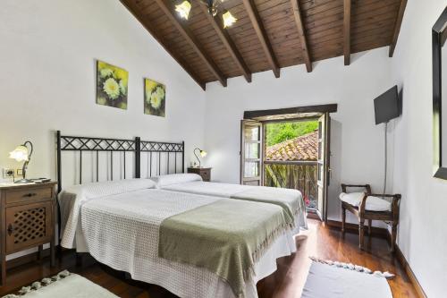 a bedroom with two beds and a window at Casa De Aldea La Venta Los Probes in Llanes