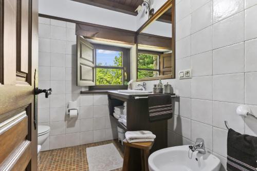 a bathroom with a sink and a toilet and a window at Casa De Aldea La Venta Los Probes in Llanes