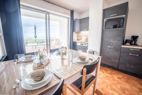 une salle à manger avec une table et une grande fenêtre dans l'établissement La Perle Bleue Vue sur mer-Terrasse-Parking-Plage Top ProsConciergerie Palavas-les-Flots, à Palavas-les-Flots