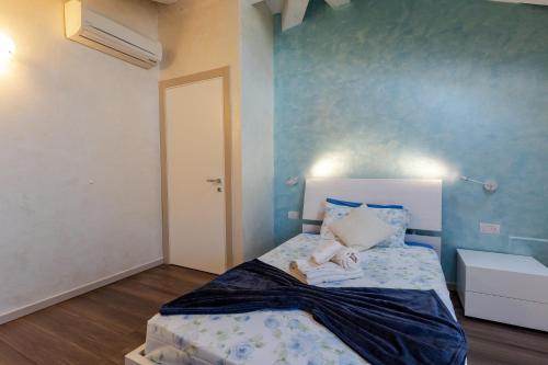 a bedroom with a bed with a blue wall at Villa Vitali - Bellagio in Bellagio