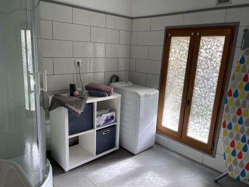 a small bathroom with a refrigerator and a window at Les Gîtes de Monthermé La Maison authentique du centre historique in Monthermé