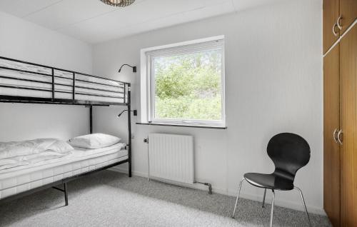 a bedroom with a bed and a chair and a window at Lovely Home In Højslev With Wifi in Højslev