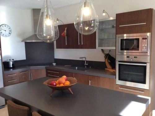 - une cuisine avec un bol de fruits sur une table dans l'établissement Bastide Languedocienne de Standing - Pézenas LE CLOS DE L'AMANDIER, à Pézenas
