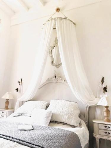 - une chambre blanche avec un lit à baldaquin blanc dans l'établissement Appartement spacieux avec deux chambres au Château, à Valence