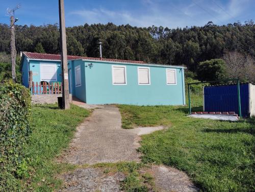 ein blaues Gebäude neben einer unbefestigten Straße in der Unterkunft Casa pantin valdoviño in Pantín