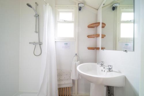 Baño blanco con lavabo y espejo en Kite - Exton Park, 