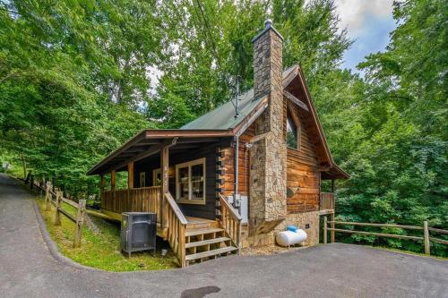 a small log cabin with a porch and a tv at Sunrise Woods Retreat by Eden Crest in Sevierville