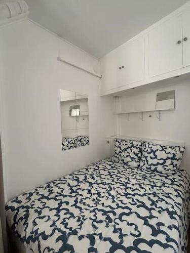 une chambre avec un lit dans une pièce blanche dans l'établissement Your Parisian Home 10 min walk from Eiffel Tower, à Paris