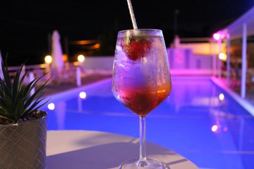 Tropicana Inn في نيدري: مشروب في كأس النبيذ بجانب المسبح