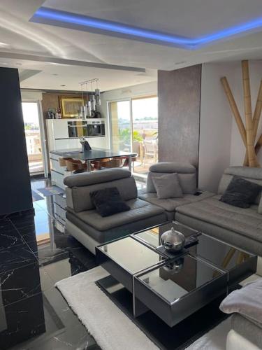 un salon avec un canapé et une table en verre dans l'établissement T3 de grand standing, à Montpellier