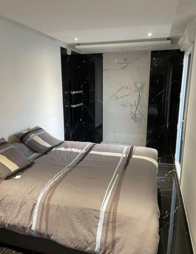 - une chambre avec un lit et une paroi en verre dans l'établissement T3 de grand standing, à Montpellier