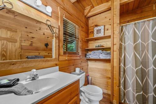 a bathroom with a sink and a toilet in a log cabin at Sunrise Woods Retreat by Eden Crest in Sevierville