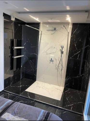 La salle de bains est pourvue d'une douche en marbre noir. dans l'établissement T3 de grand standing, à Montpellier