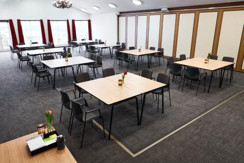 a large room with tables and chairs and windows at Montra Hotel Sabro Kro in Sabro