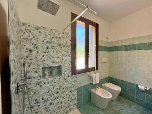 a bathroom with a shower and a toilet and a window at Casa Miraflores in Cefalù
