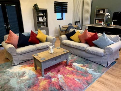 a living room with two couches and a coffee table at Tank Barn at Brook House, Nestled in the Welsh Hills, a delightful retreat in Welshpool