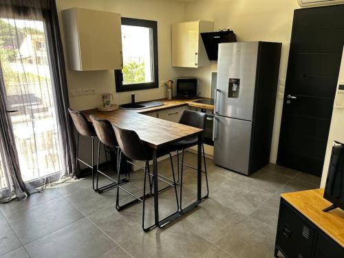 une cuisine avec une table en bois et un réfrigérateur dans l'établissement L étoile de mer logement 2, à Sainte-Marie-la-Mer