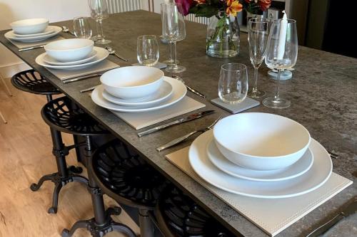 a table with plates and bowls and glasses on it at Tank Barn at Brook House, Nestled in the Welsh Hills, a delightful retreat in Welshpool