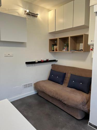 - un salon doté d'un canapé brun dans l'établissement Cosy studio Paris Opera with lift Ascenseur, à Paris