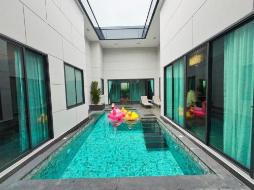 une piscine dans un immeuble avec une maison dans l'établissement PNT VILLA PATTAYa, à Nong Prue