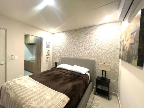 a small bedroom with a bed and a bathroom at Luxury aprt in front of Fundidora Park, gym, BBQ. in Monterrey