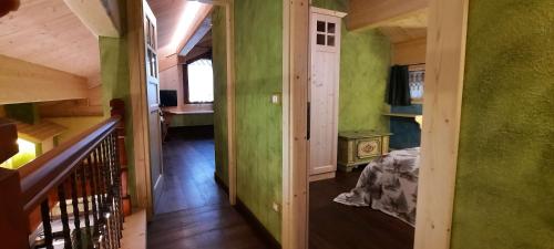 a room with green walls and a bedroom with a bed at Chalet Pra Dell OSTIO Primiero San Martino di Castrozza in Fiera di Primiero