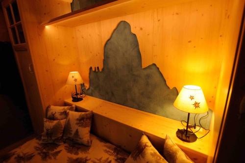 a room with a bed with two lamps and pillows at Chalet Pra Dell OSTIO Primiero San Martino di Castrozza in Fiera di Primiero