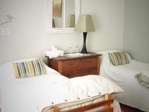 a bedroom with two beds and a dresser with a mirror at The Lighthouse Guesthouse in Colesberg