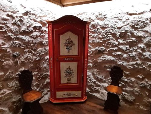 a red clock on the side of a wall at Chalet Pra Dell OSTIO Primiero San Martino di Castrozza in Fiera di Primiero