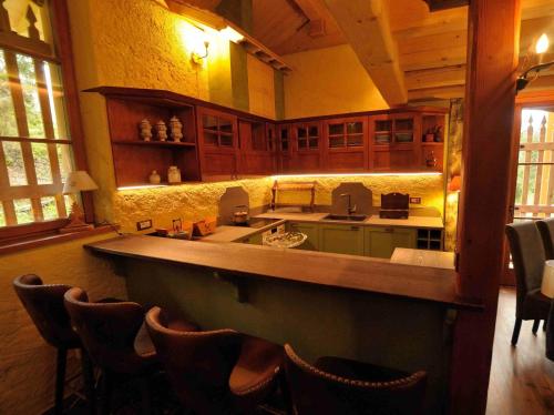a large kitchen with a counter and some chairs at Chalet Pra Dell OSTIO Primiero San Martino di Castrozza in Fiera di Primiero