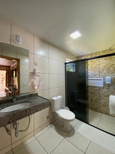 a bathroom with a toilet and a sink and a shower at Hotel Fazenda Casarão do Vale in Massaranduba