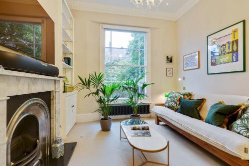 a living room with a couch and a fireplace at Bright Camberwell Georgian Apartment in London