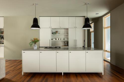 a kitchen with white cabinets and a counter at Idyll Reserve - Hocking Hills in South Bloomingville