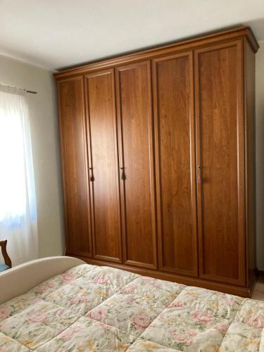 a bedroom with a bed and wooden cabinets at Al Civico 40 in Fai della Paganella
